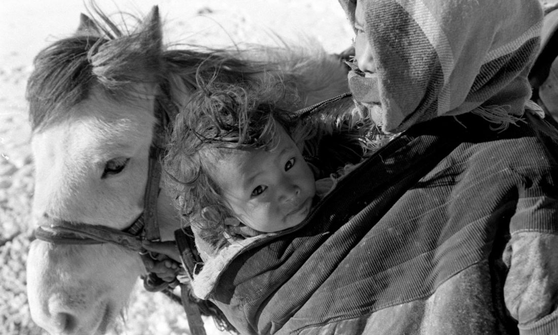 1990年3月，西藏當(dāng)雄縣納木湖鄉(xiāng)三村女牧民斯卓不畏嚴(yán)寒，懷抱幼子，準(zhǔn)備到遠(yuǎn)處放牧。新華社記者覺果攝