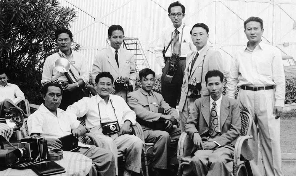 新華社記者錢嗣杰（站立者右二）在采訪會(huì)議開幕式后和外國記者在會(huì)場外休息。