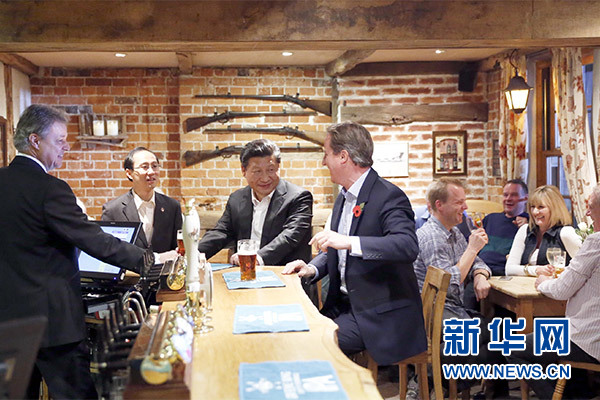 這是會晤結(jié)束后，習(xí)近平在卡梅倫陪同下乘車前往當(dāng)?shù)匦℃?zhèn)體驗(yàn)酒吧文化。新華社記者 鞠鵬 攝